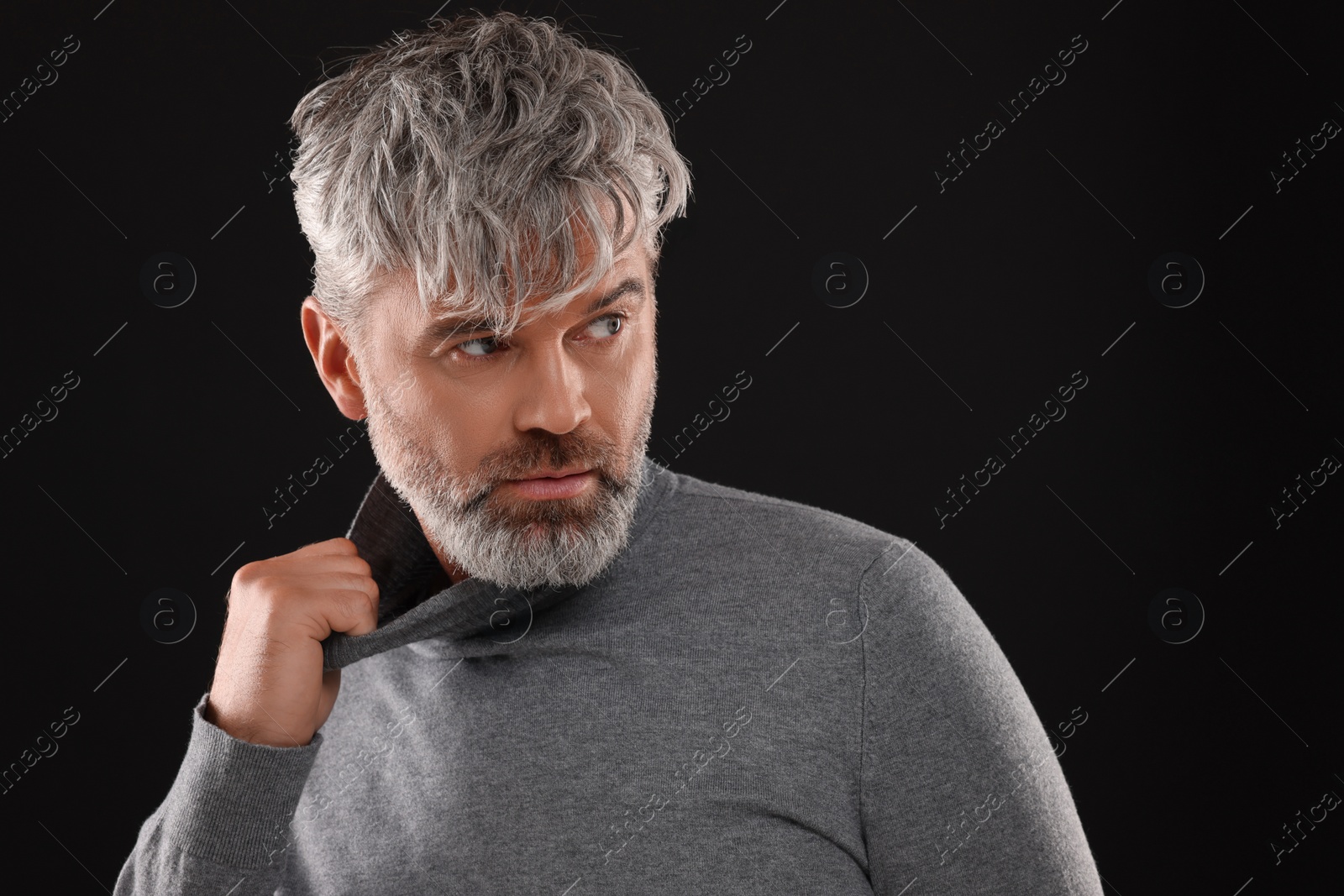 Photo of Portrait of confident man with beautiful hairstyle on black background