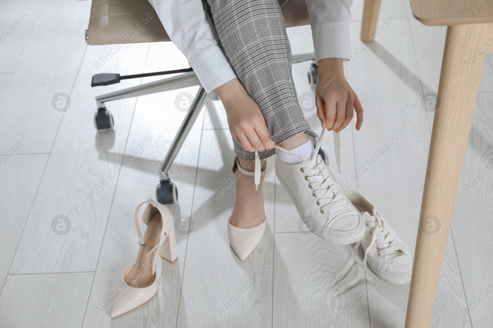 Photo of Woman changing shoes at workplace in office, closeup