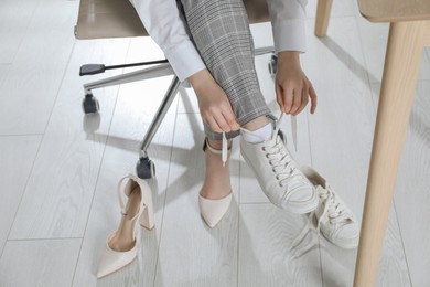 Woman changing shoes at workplace in office, closeup