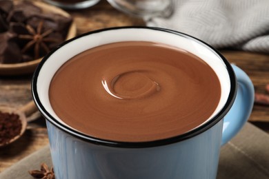 Photo of Yummy hot chocolate in mug on table, closeup