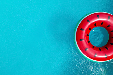 Top view of inflatable ring floating in swimming pool, space for text. Summer vacation