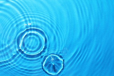 Rippled surface of clear water on light blue background, top view