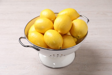 Many fresh ripe lemons on wooden table