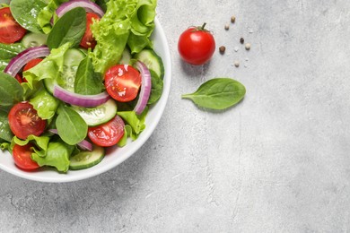 Delicious vegetable salad on light grey table, flat lay. Space for text