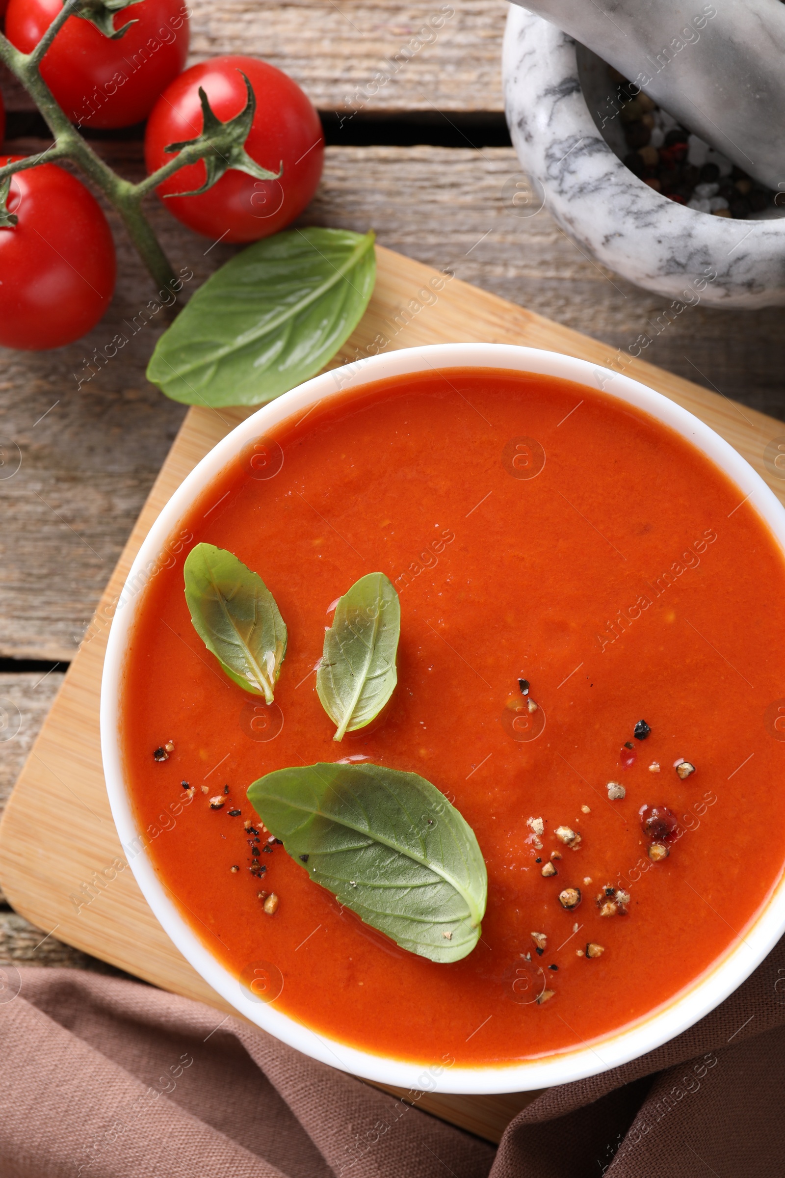 Photo of Delicious tomato soup on wooden table, flat lay