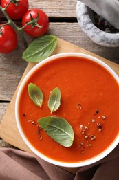 Photo of Delicious tomato soup on wooden table, flat lay