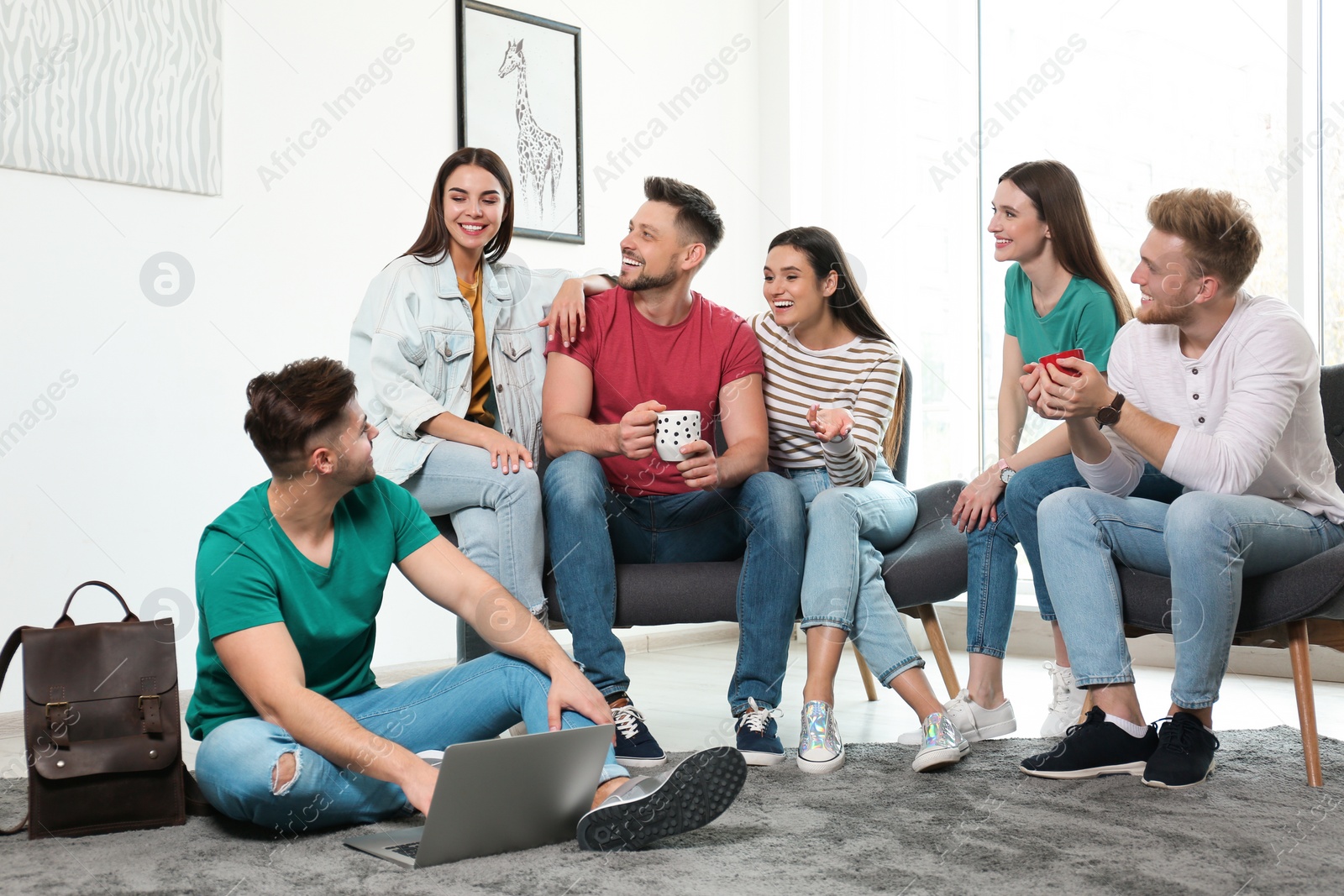 Photo of Group of happy people with laptop in living room