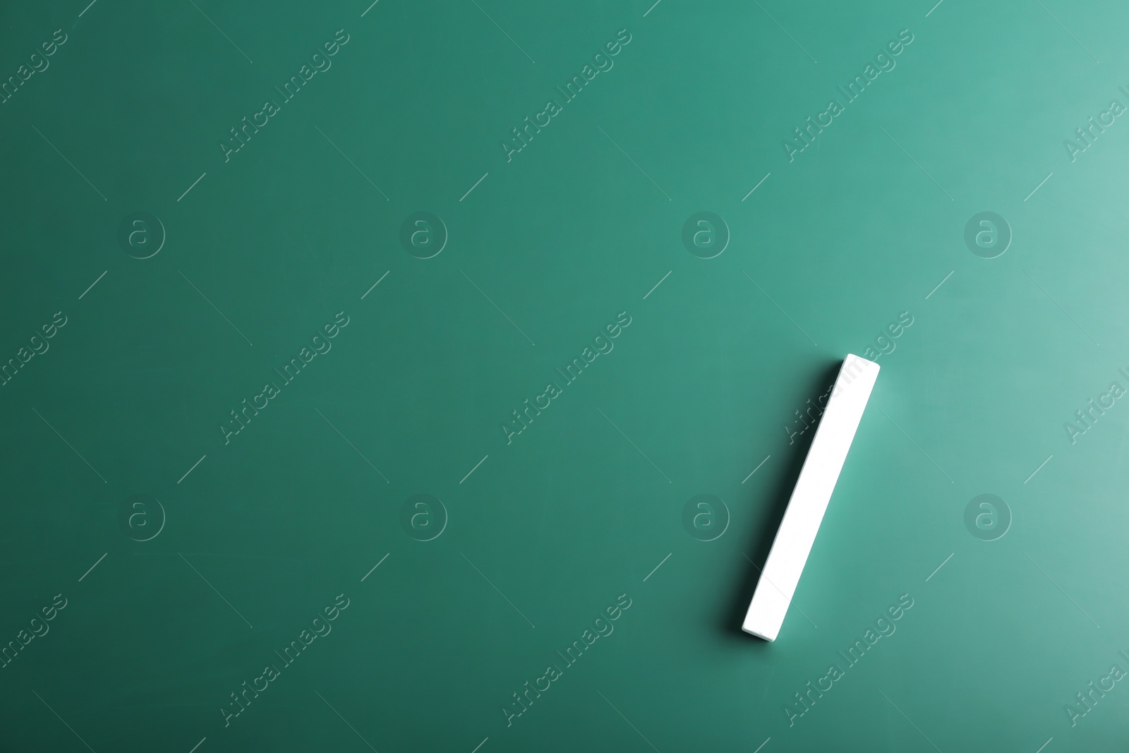 Photo of Piece of chalk on green background, top view