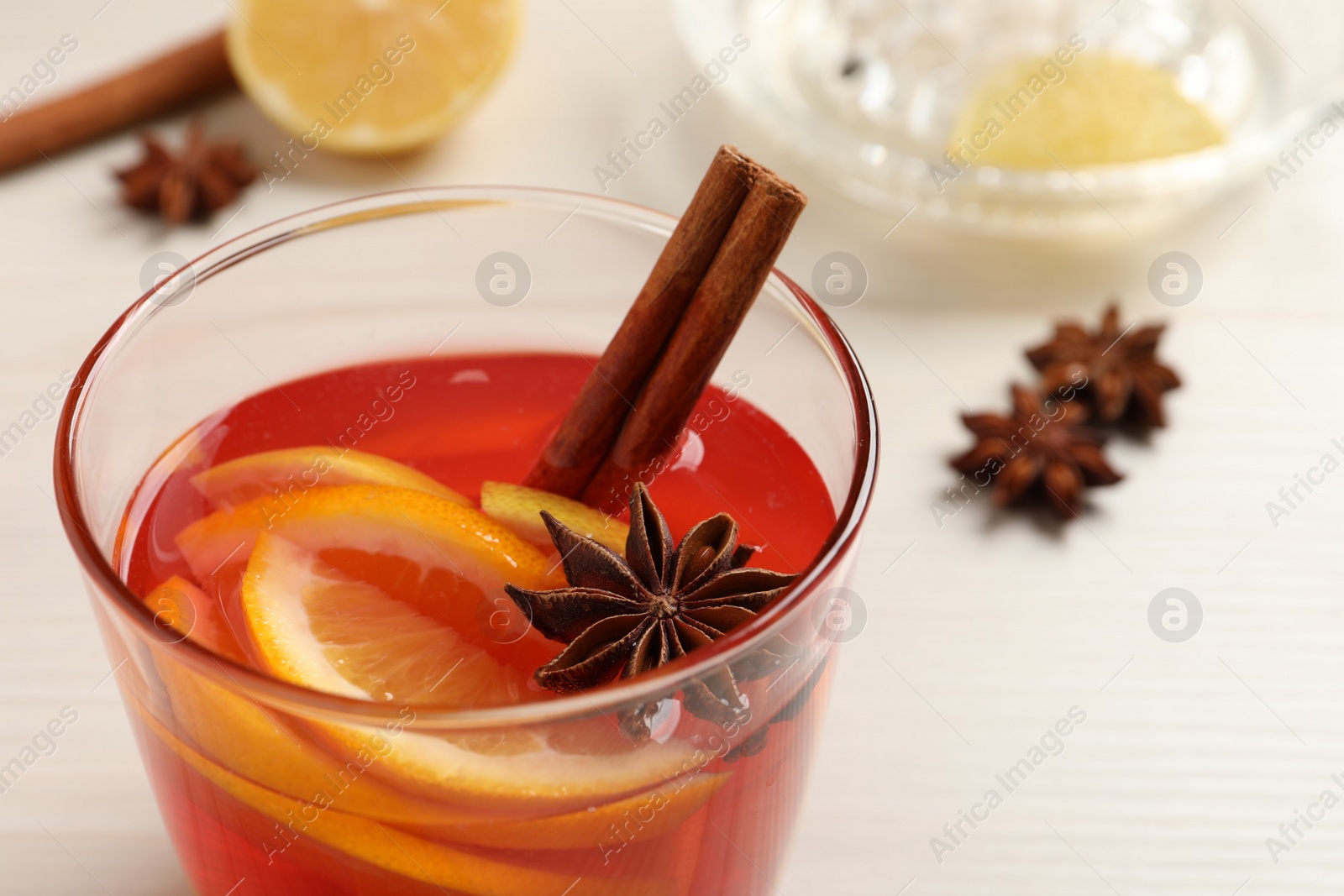 Photo of Aromatic punch drink on white table, closeup. Space for text