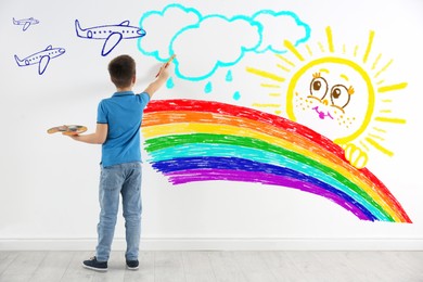 Image of Cute child boy drawing of colorful dye on white wall indoors