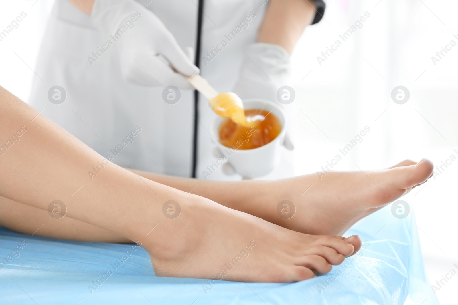 Photo of Woman getting wax epilation in salon