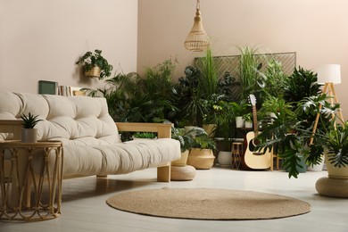 Living room interior with stylish furniture and different houseplants