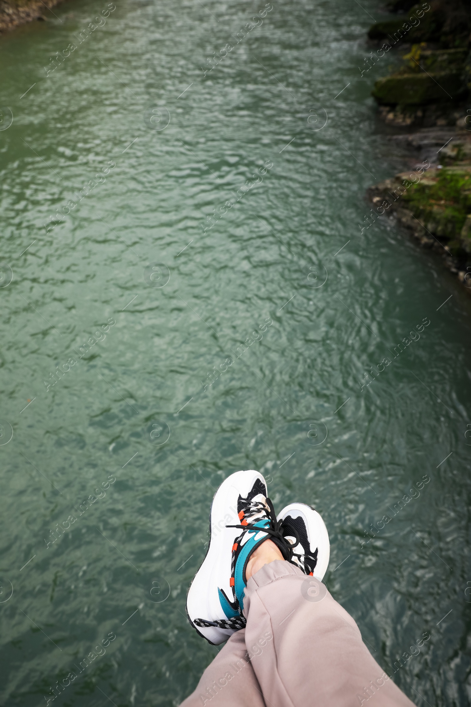 Photo of Man holding feet over river, top view