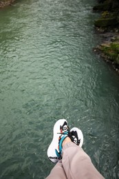 Man holding feet over river, top view