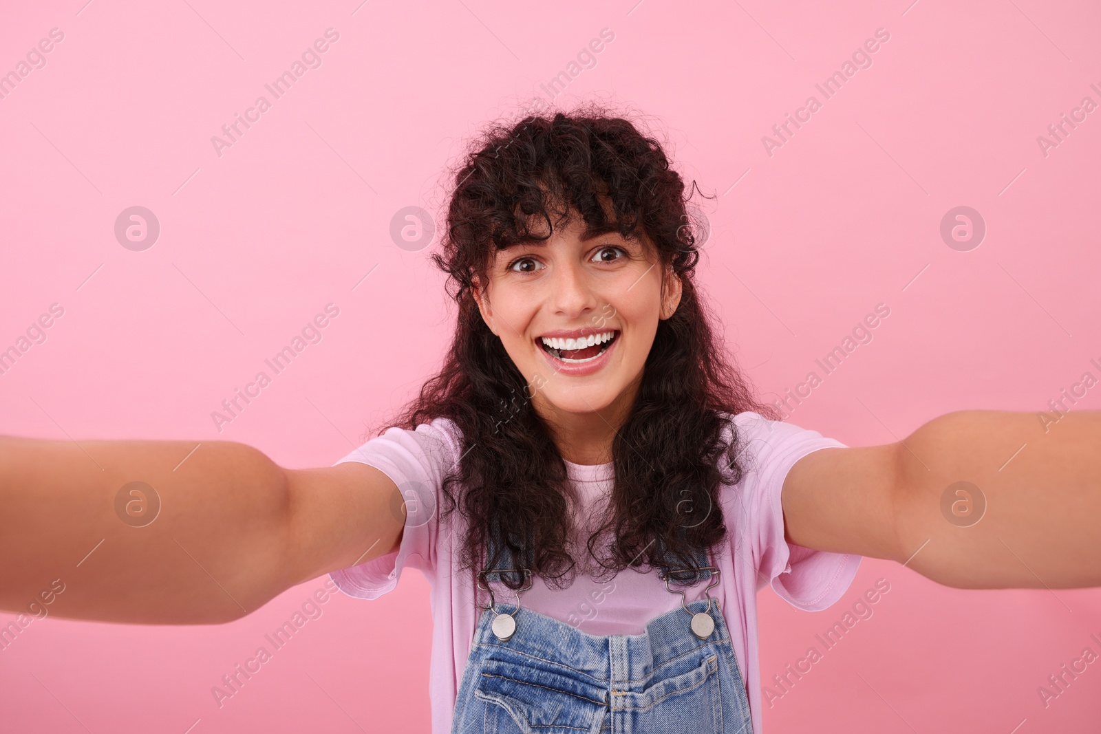 Photo of Beautiful woman taking selfie on pink background