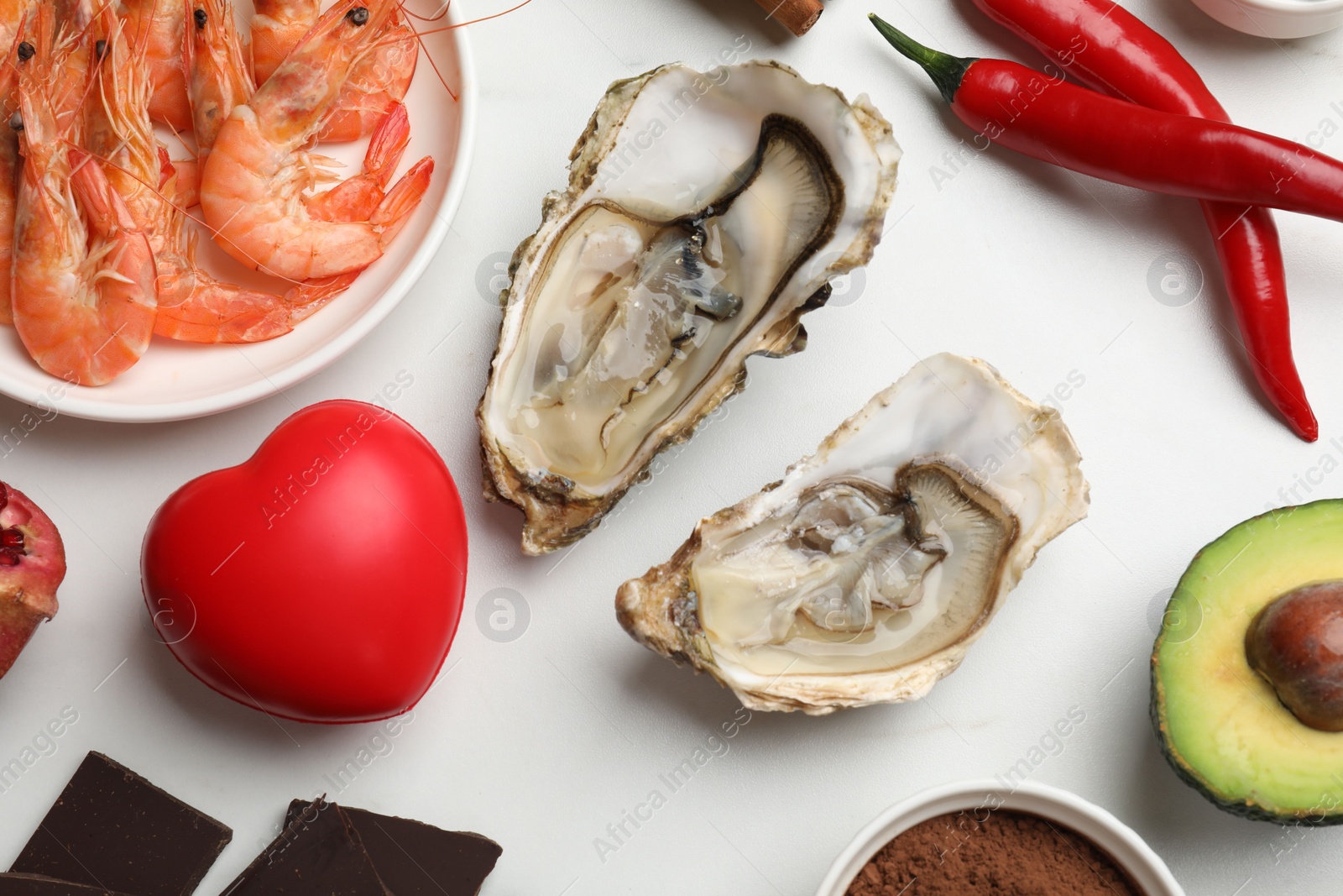 Photo of Natural aphrodisiac. Different food products and red decorative heart on white table, flat lay