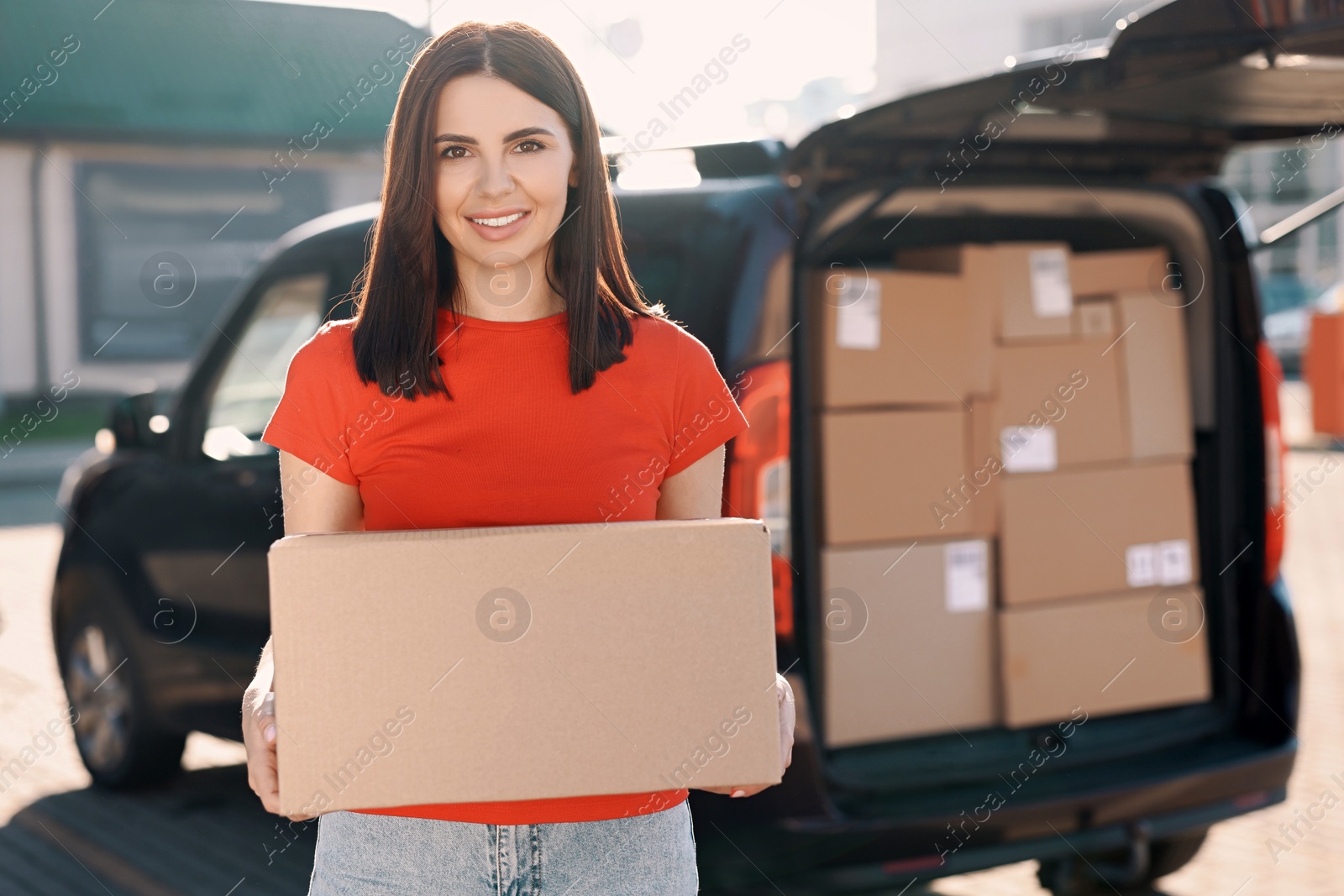 Photo of Courier with parcel near delivery van outdoors, space for text