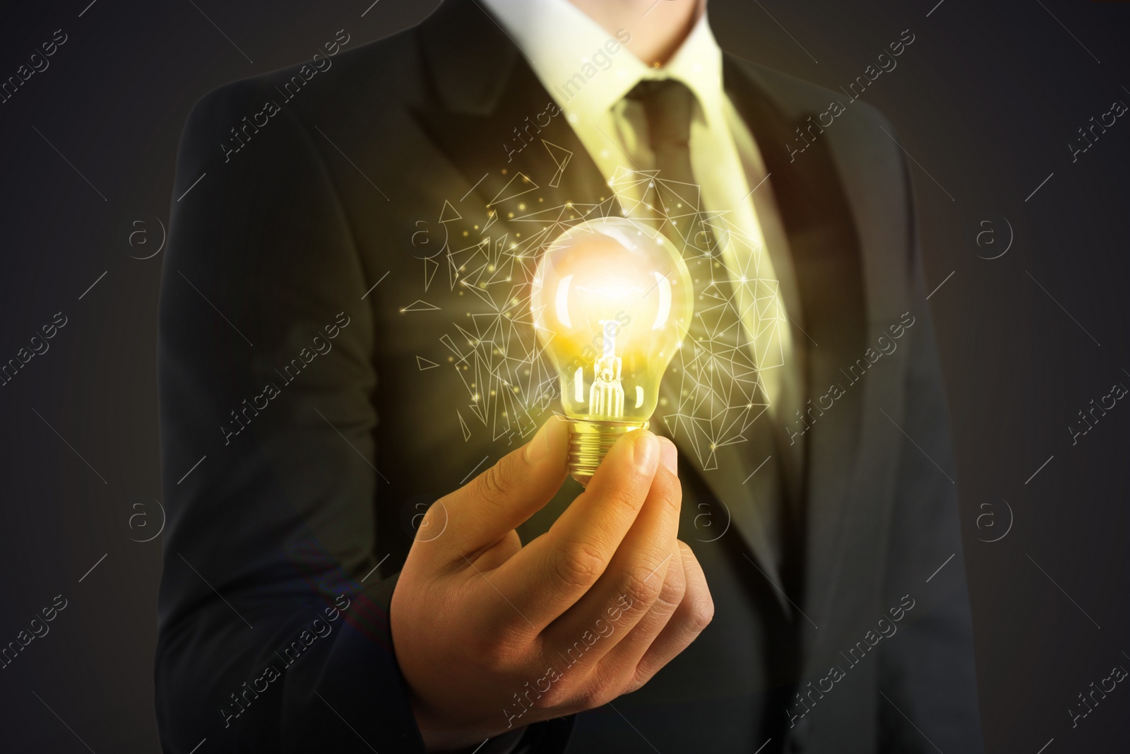 Image of Glow up your ideas. Businessman holding light bulb on dark background, closeup