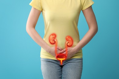 Woman suffering from cystitis on light blue background, closeup. Illustration of urinary system