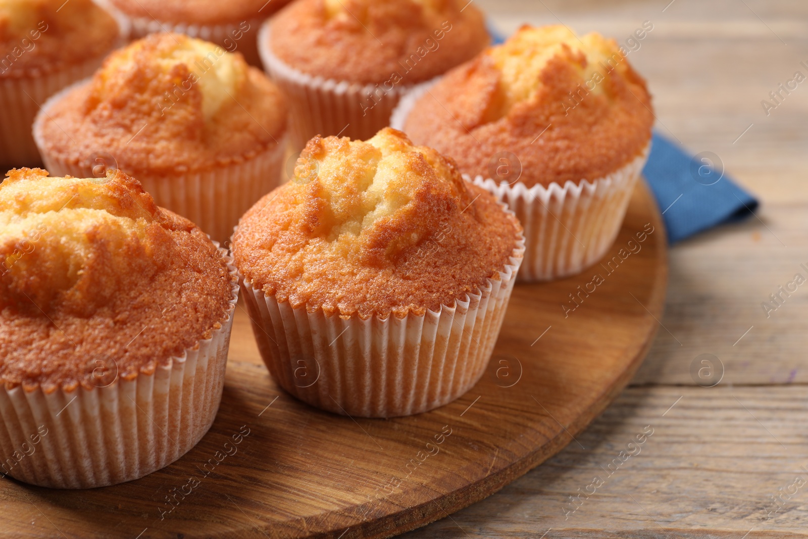 Photo of Delicious sweet muffins on wooden table, closeup. Space for text