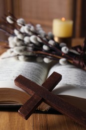 Photo of Cross and Bible on wooden table, closeup