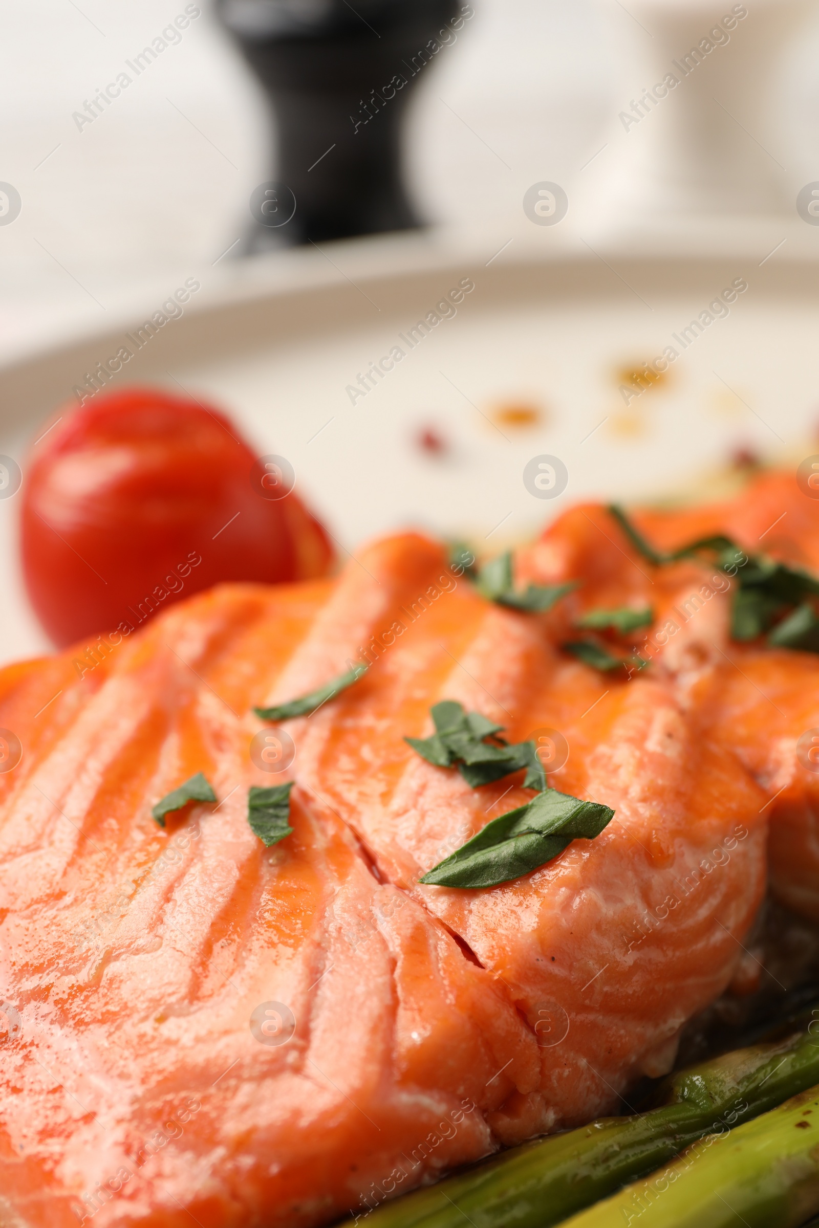 Photo of Tasty grilled salmon with tomato and spices on plate, closeup