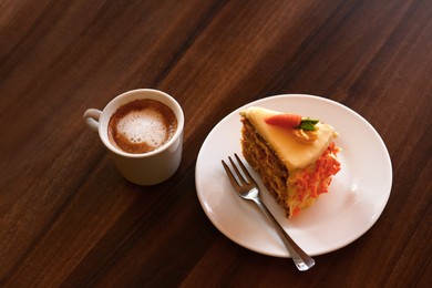 Photo of Delicious cake and cup of hot coffee on wooden table