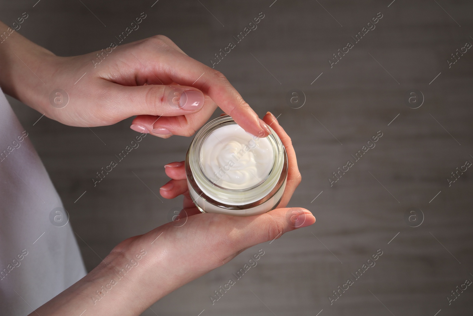 Photo of Woman applying hand cream indoors, above view