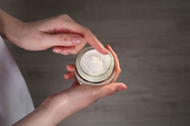 Woman applying hand cream indoors, above view