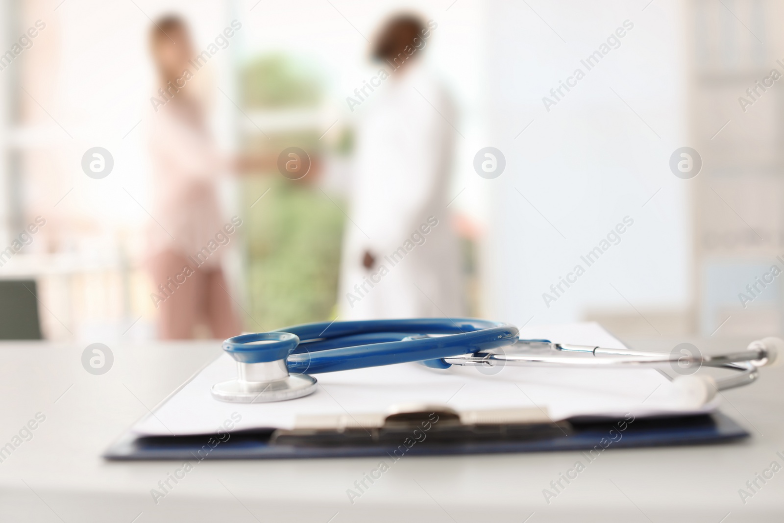 Photo of Stethoscope and clipboard on table in doctor's office. Patient consultation