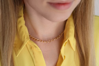 Photo of Closeup view of woman wearing metal chain. Luxury jewelry