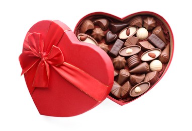 Photo of Heart shaped box with delicious chocolate candies isolated on white, top view