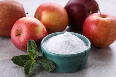 Photo of Sweet fructose powder, mint leaves and apples on light grey table