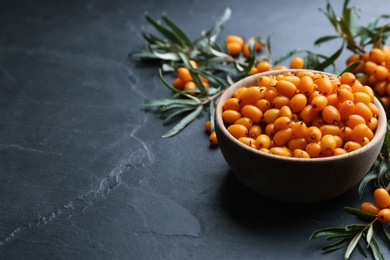 Fresh ripe sea buckthorn on black table. Space for text