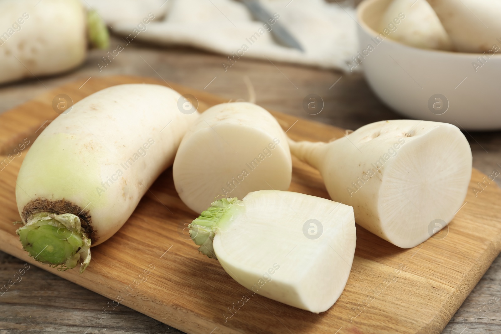 Photo of Raw white turnips on wooden table, closeup