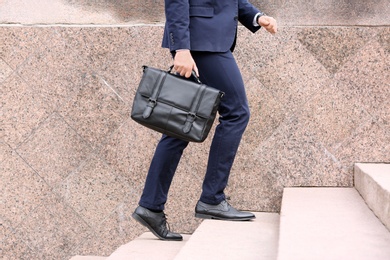 Businessman with black briefcase in hand outdoors