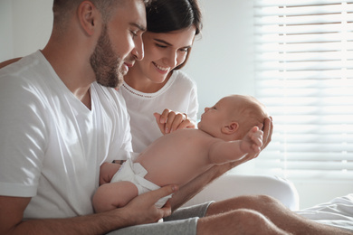 Photo of Happy couple with their newborn baby at home