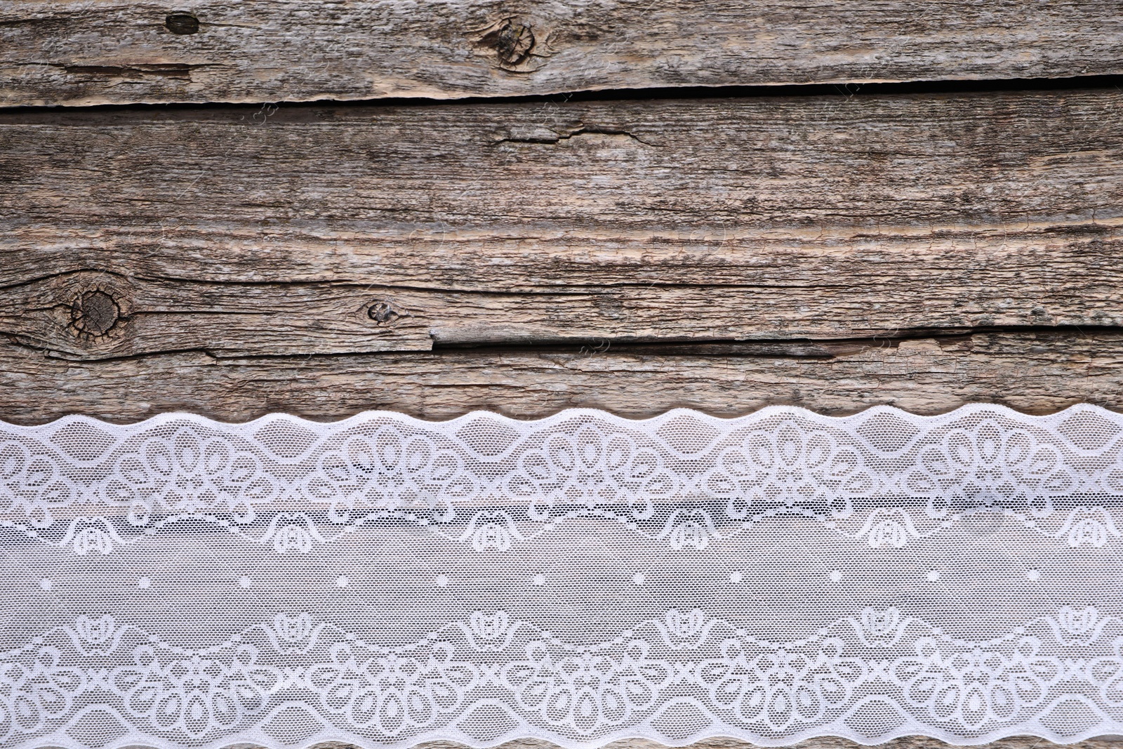 Photo of White lace on wooden table, top view. Space for text