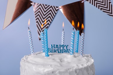 Delicious cake with cream and burning candles on light blue background, closeup