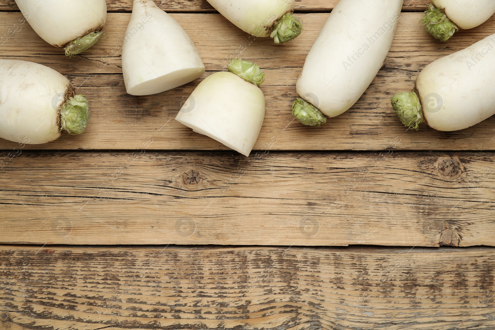 Photo of White turnips on wooden table, flat lay. Space for text