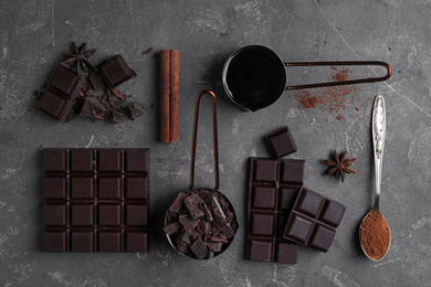 Flat lay composition with dark chocolate on grey table