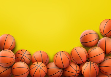 Image of Many orange basketball balls on yellow background. Space for text