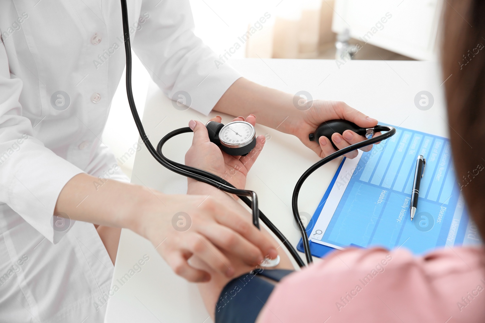 Photo of Female doctor measuring blood pressure of overweight woman in clinic