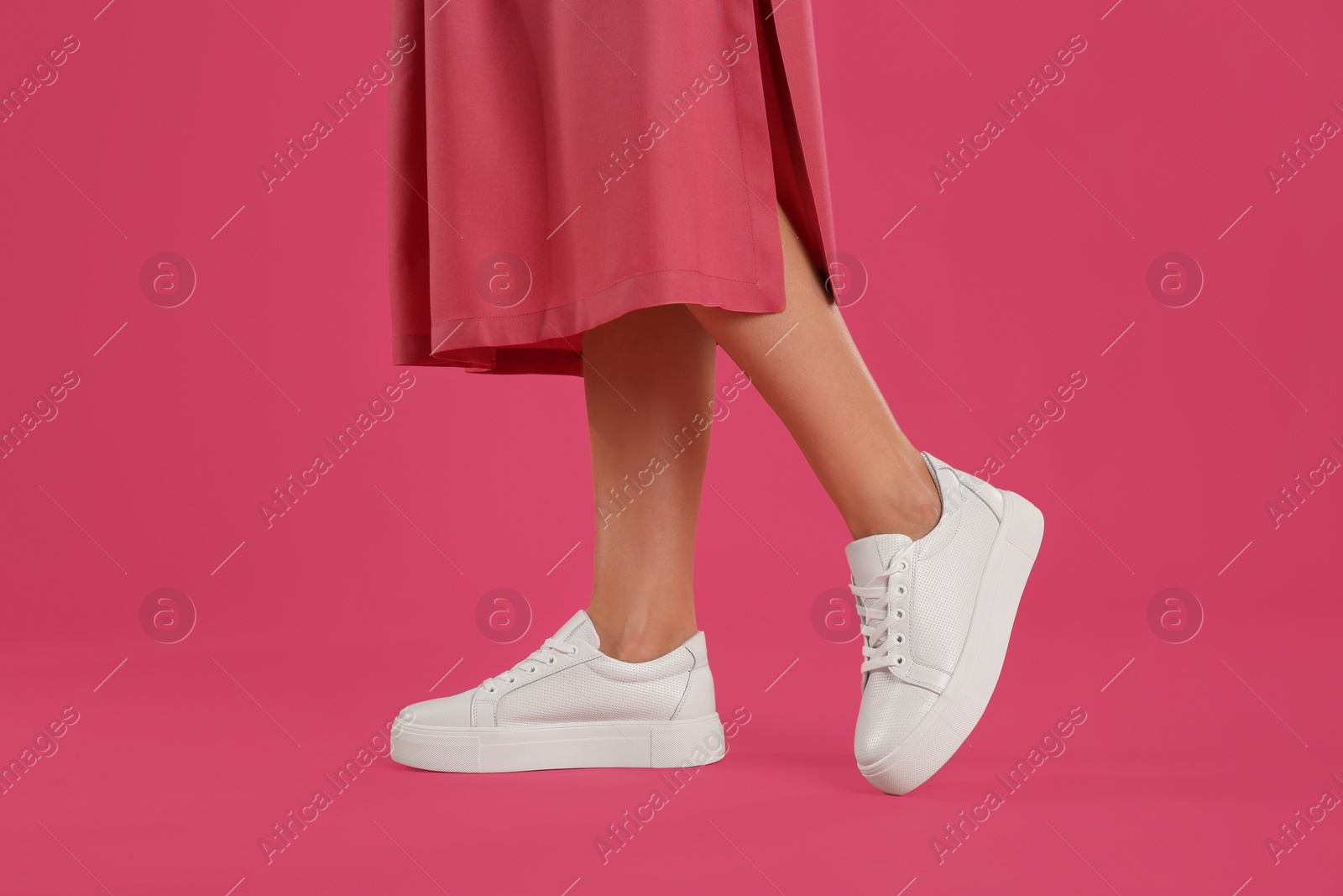 Photo of Woman wearing shoes on pink background, closeup