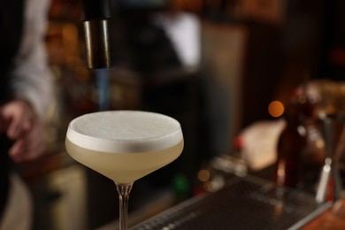 Photo of Fresh alcoholic cocktail in bar, closeup. Space for text