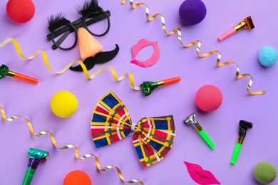Composition with clown's accessories on violet background, above view