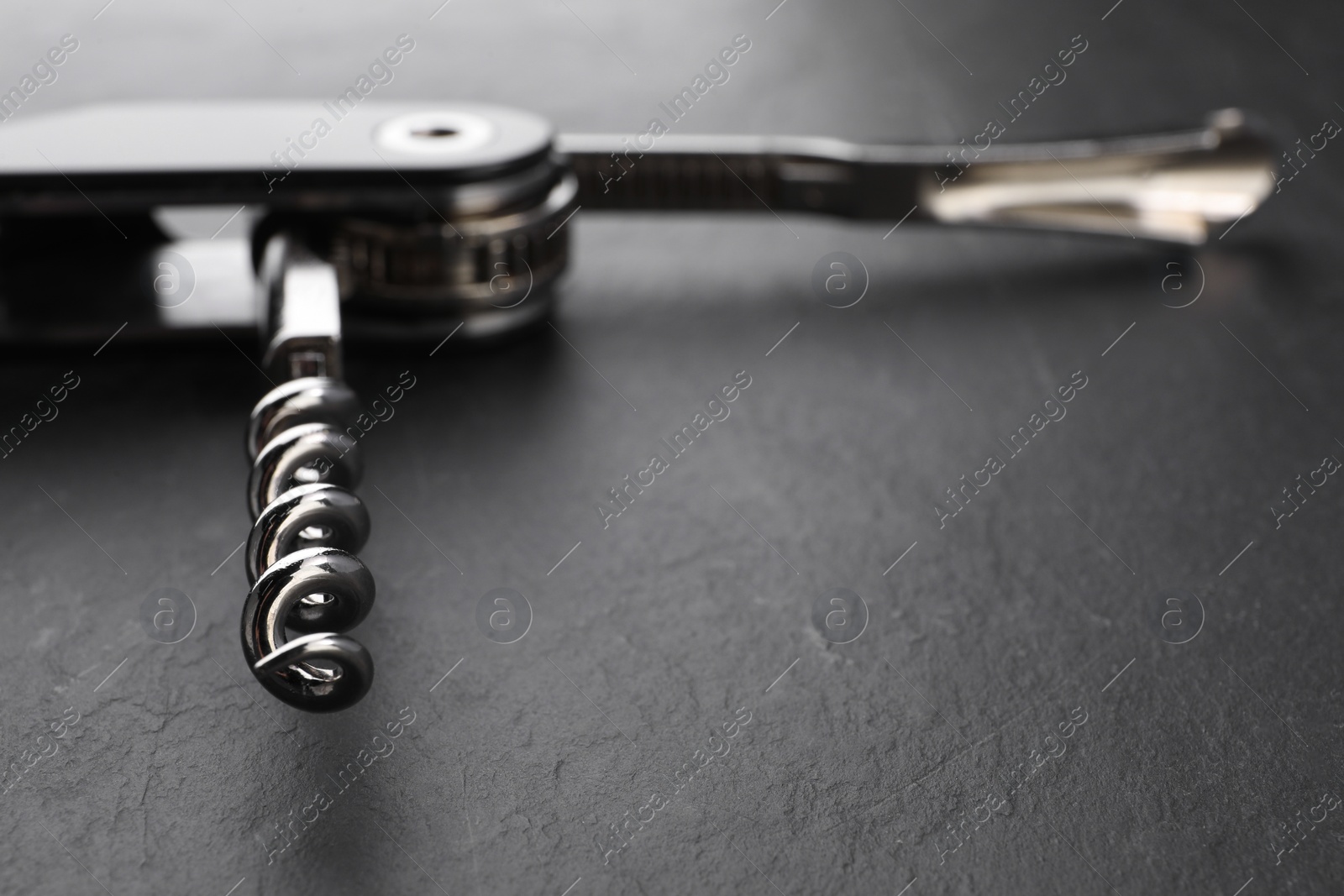 Photo of One corkscrew (sommelier knife) on grey textured table, closeup