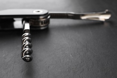 One corkscrew (sommelier knife) on grey textured table, closeup