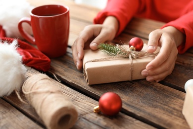 Photo of Woman with Christmas gift box at wooden table