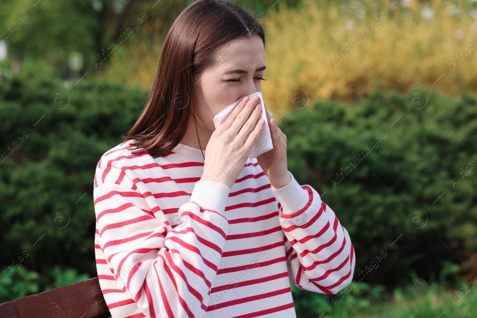 Photo of Woman with napkin suffering from seasonal allergy outdoors